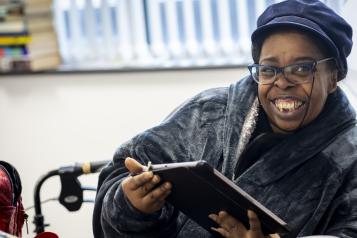 Woman smiling while holding an iPad