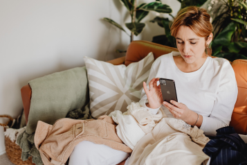 Woman using phone on sofa