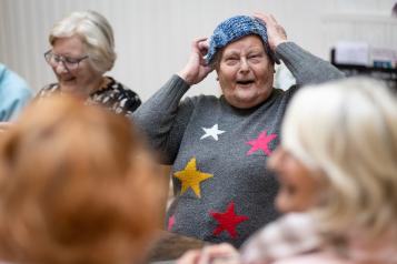 Older women sat together with knitting and laughing