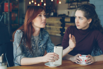 Two young women talking in a café