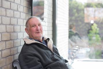 An older man sat down in a waiting area.
