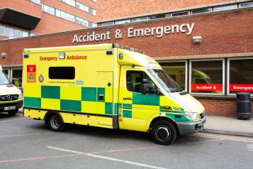 yellow and green ambulance outside a hospital