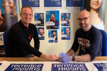 Photogrpah of Hove MP Peter Kyle, HIV Testing, Terrence Higgins Trust Posters IN foreground and Background