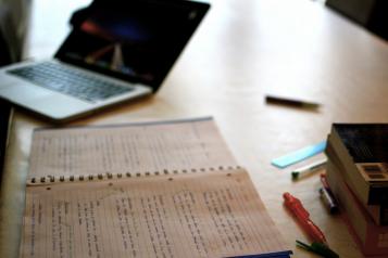 desktop with laptop and written notes on a paper pad