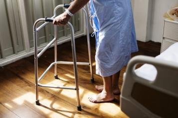 photograph, side view looking to floor, close up of patient holding zimmer frame
