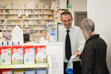 Pharmacist and customer in pharmacy.