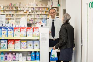 Pharmacist and customer in pharmacy.