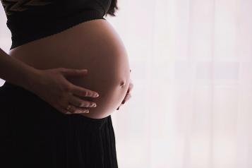 pregnany woamn, focused on stomach, standing right side of shot