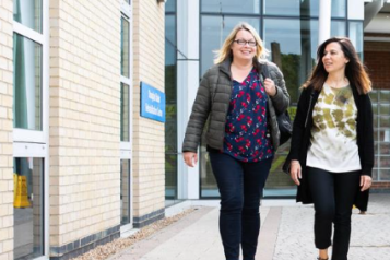 Two women walking near a hospital