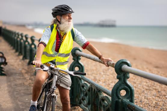 Older adult riding a bike along the Brighton seafront.