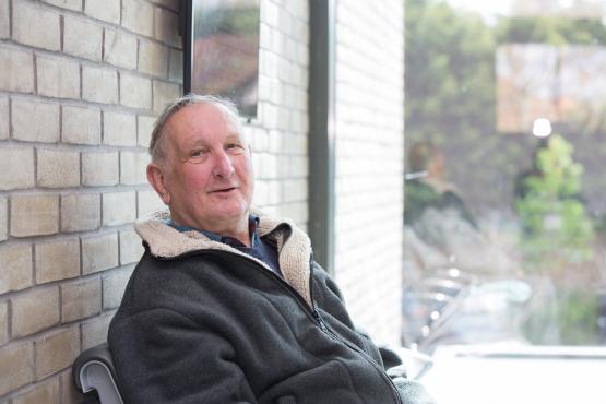An older man sat down in a waiting area.