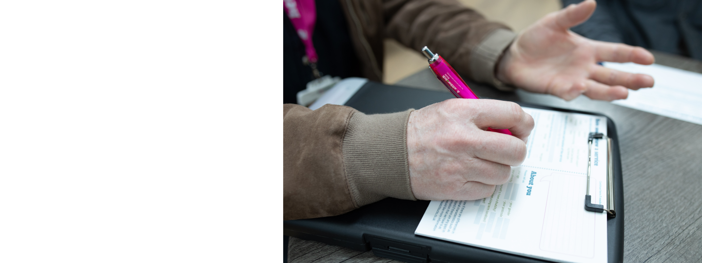 A hand holding a pen and filling out a feedback document.