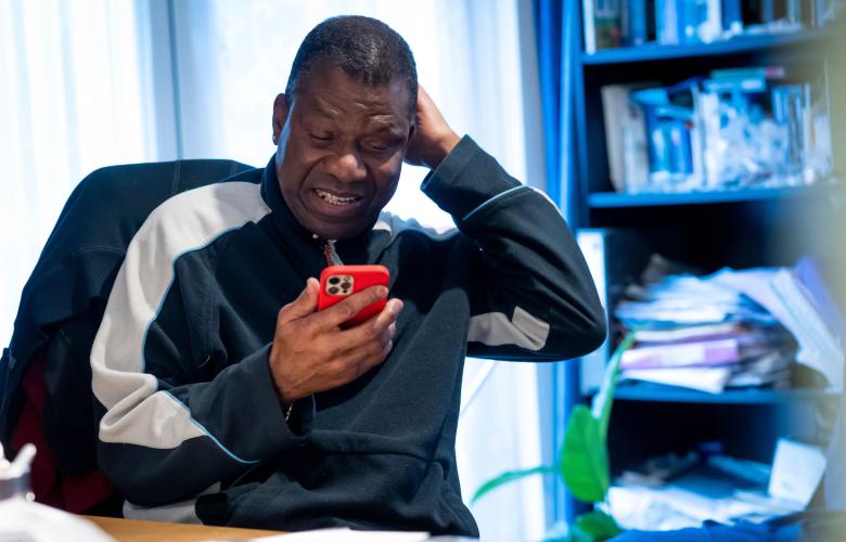 Man using his phone in an indoor setting.