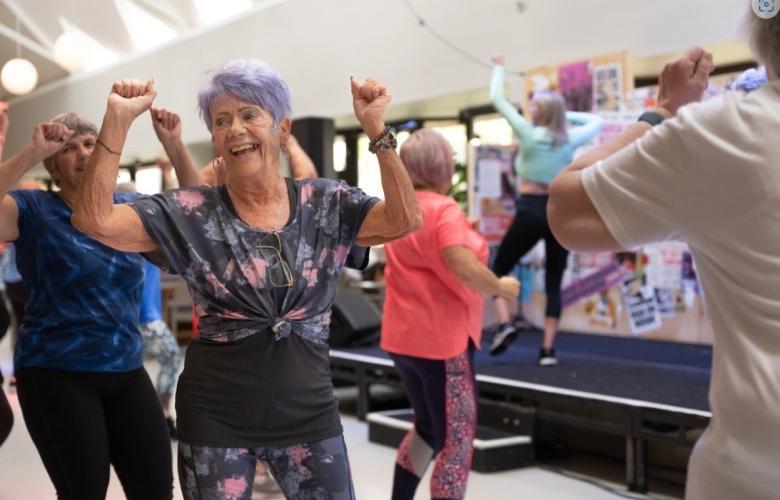 Older adults smiling while taking part in an exercise class