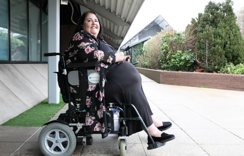 A woman in a wheelchair outside.