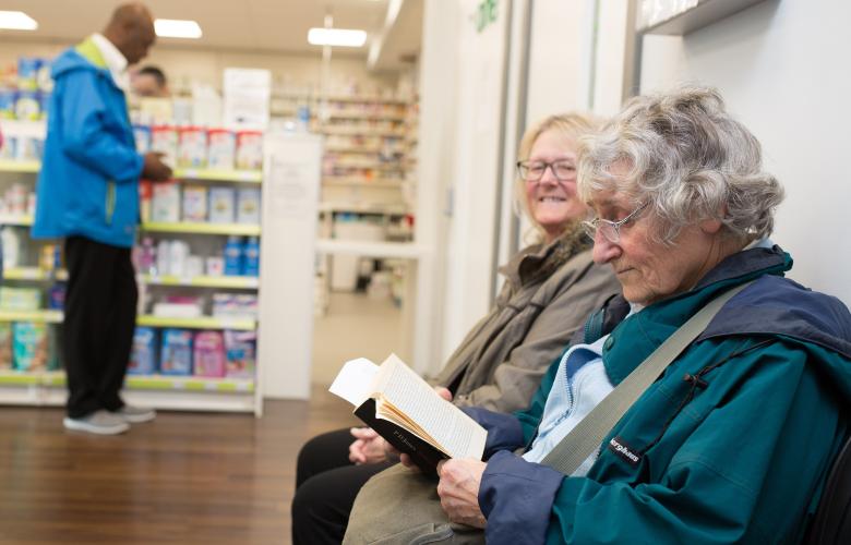 Three people waiting at a pharmacy.