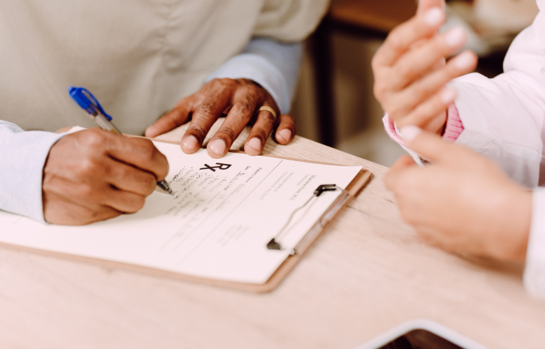 Someone filling out a form next to another person. This is a close-up shot of two sets of hands.