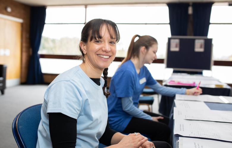 A healthcare professional smiling while sat at a desk.