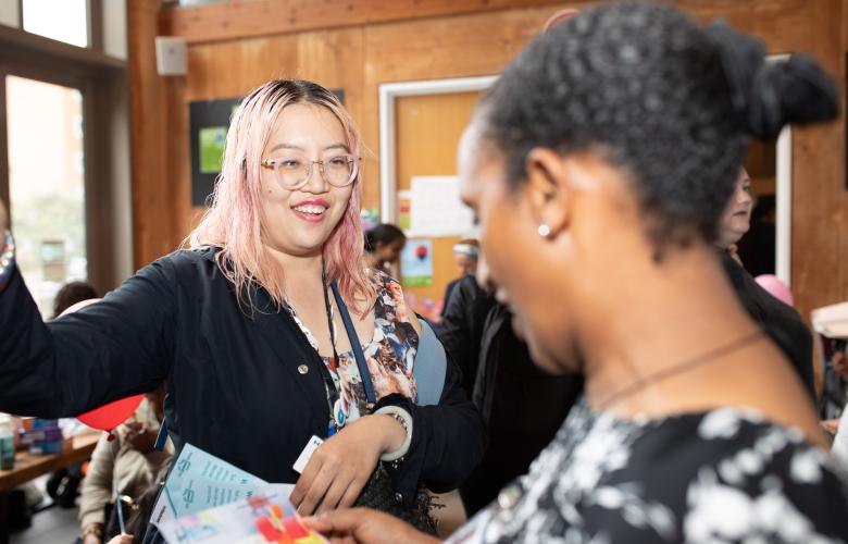 Two women talking in a busy event environment