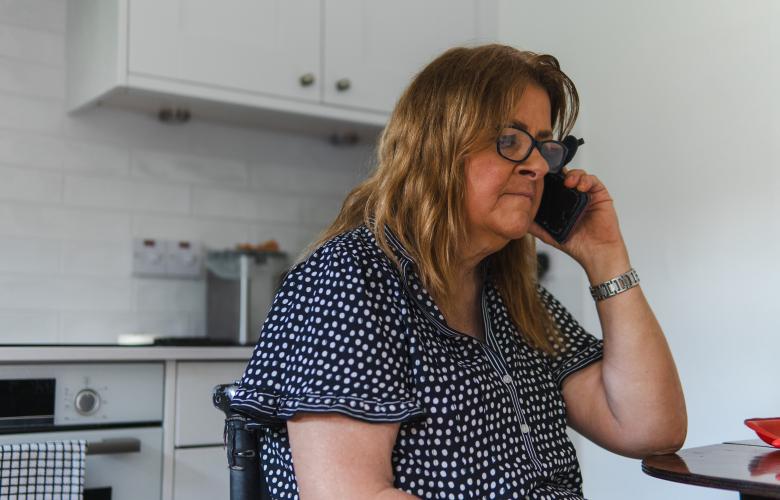 Woman using a phone in a kitchen.