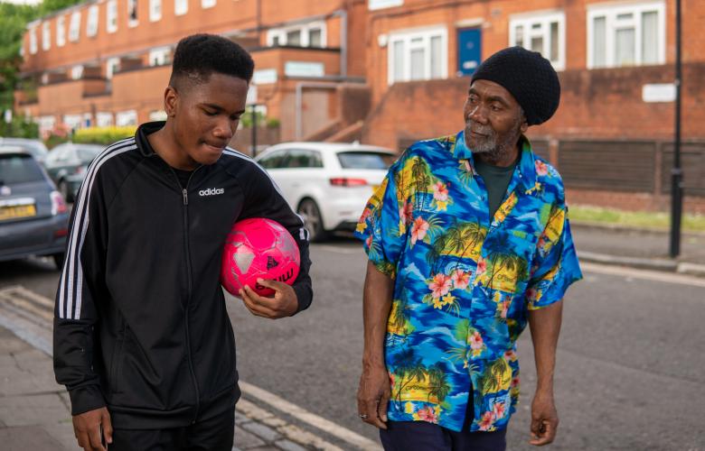 Older man and young man walking together.