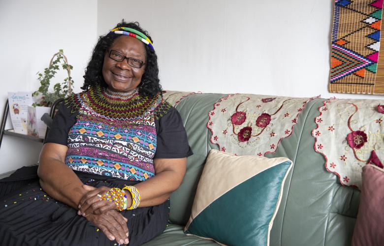 Woman sat smiling on sofa indoors.