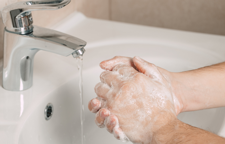 Hands being washed in a sink.