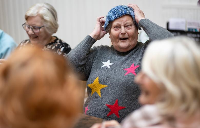 Older women sat together with knitting and laughing