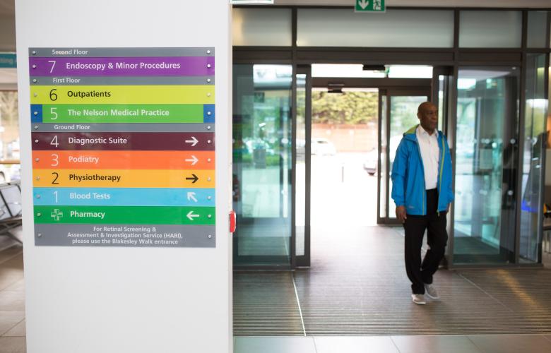 Man walking through hospital entrance.