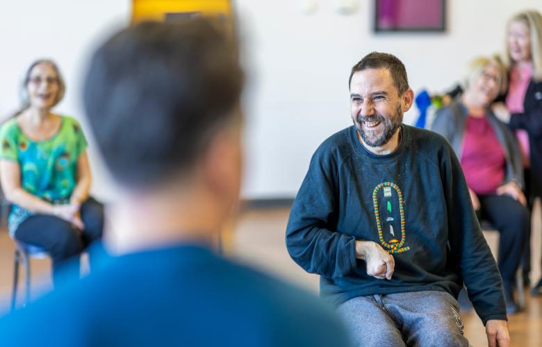 Several people sat smiling in an indoor setting.