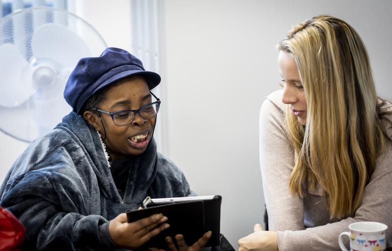 Two women looking at an iPad together.