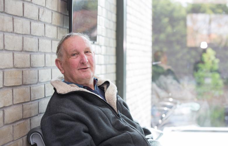 An older man sat down in a waiting area.