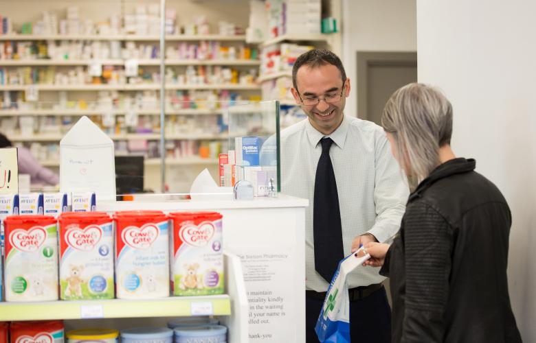 Pharmacist and customer in pharmacy.