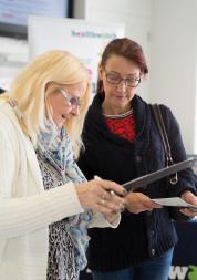 A woman interviewing another woman with a clipboard.