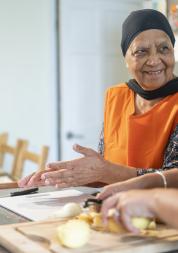 An older woman and another person preparing food together.
