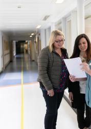 Nurse speaking to people in a hospital corridor