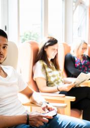 Man and women sitting in waiting roon chairs