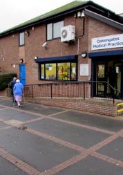 side view of GP Practice, couple walking towards entrance