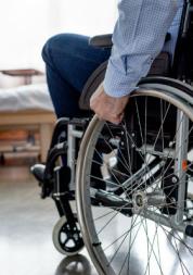 man in wheelchair by bed