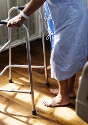 photograph, side view looking to floor, close up of patient holding zimmer frame