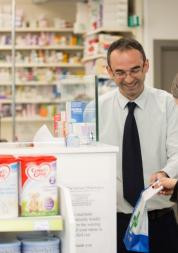 Male pharmacist serving a female customer