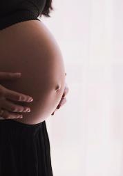 pregnany woamn, focused on stomach, standing right side of shot