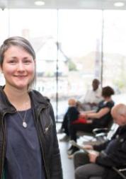 woman standing front of frame, to left, standing in GP Surgery